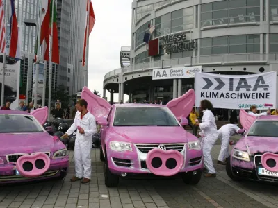 Greenpeace activists paint cars of German manufacturers BMW, Volkswagen and Audi pink and drape swine snouts and ears during a protest against air pollution in front of the international car show IAA in Frankfurt September 13, 2007.     REUTERS/Alex Grimm (GERMANY)