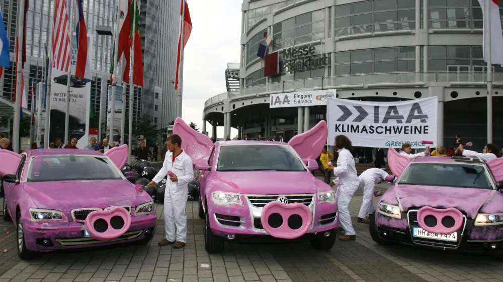 Greenpeace activists paint cars of German manufacturers BMW, Volkswagen and Audi pink and drape swine snouts and ears during a protest against air pollution in front of the international car show IAA in Frankfurt September 13, 2007.     REUTERS/Alex Grimm (GERMANY)