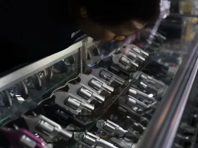 Sales associate Elsworth Andrews arranges guns on display at Burbank Ammo & Guns in Burbank, Calif., Thursday, June 23, 2022. The Supreme Court has ruled that Americans have a right to carry firearms in public for self-defense, a major expansion of gun rights. The court struck down a New York gun law in a ruling expected to directly impact half a dozen other populous states. (AP Photo/Jae C. Hong)