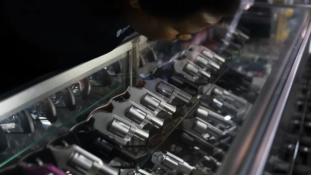 Sales associate Elsworth Andrews arranges guns on display at Burbank Ammo & Guns in Burbank, Calif., Thursday, June 23, 2022. The Supreme Court has ruled that Americans have a right to carry firearms in public for self-defense, a major expansion of gun rights. The court struck down a New York gun law in a ruling expected to directly impact half a dozen other populous states. (AP Photo/Jae C. Hong)