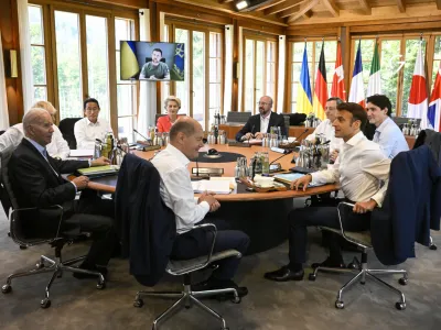 From front center clockwise, Germany's Chancellor Olaf Scholz, US President Joe Biden, Britain's Prime Minister Boris Johnson, Japan's Prime Minister Fumio Kishida, European Commission President Ursula von der Leyen, European Council President Charles Michel, Italy's Prime Minister Mario Draghi, Canada's Prime Minister Justin Trudeau and France's President Emmanuel Macron have taken seat at a round table as Ukraine's President Volodymyr Zelensky addresses the G7 leaders via video link during their working session at Castle Elmau in Kruen, near Garmisch-Partenkirchen, Germany, on Monday, June 27, 2022. The Group of Seven leading economic powers are meeting in Germany for their annual gathering Sunday through Tuesday. (Tobias Schwarz/Pool Photo via AP)