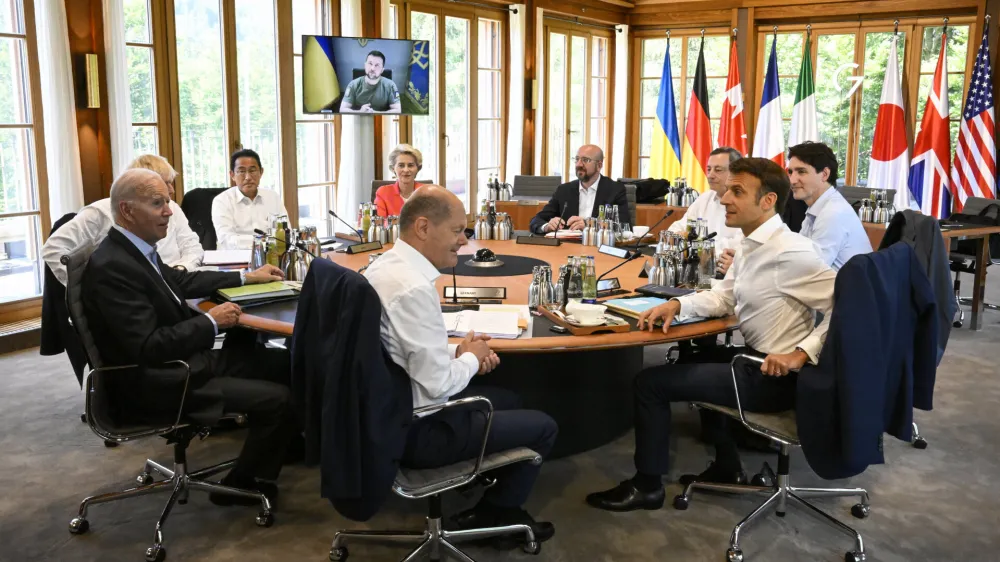 From front center clockwise, Germany's Chancellor Olaf Scholz, US President Joe Biden, Britain's Prime Minister Boris Johnson, Japan's Prime Minister Fumio Kishida, European Commission President Ursula von der Leyen, European Council President Charles Michel, Italy's Prime Minister Mario Draghi, Canada's Prime Minister Justin Trudeau and France's President Emmanuel Macron have taken seat at a round table as Ukraine's President Volodymyr Zelensky addresses the G7 leaders via video link during their working session at Castle Elmau in Kruen, near Garmisch-Partenkirchen, Germany, on Monday, June 27, 2022. The Group of Seven leading economic powers are meeting in Germany for their annual gathering Sunday through Tuesday. (Tobias Schwarz/Pool Photo via AP)