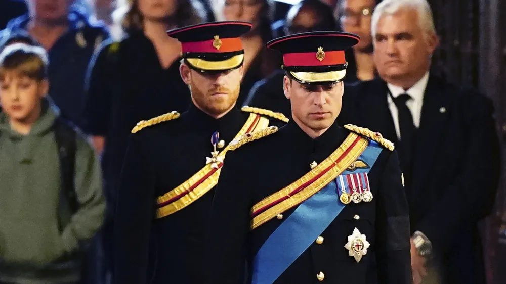 Prince William, the prince of Wales, right, and Prince Harry attend the vigil of the Queen's grandchildren around the coffin, as it lies in state on the catafalque in Westminster Hall, at the Palace of Westminster, London, Saturday, Sept. 17, 2022, ahead of her funeral on Monday. (Aaron Chown/Pool Photo via AP)