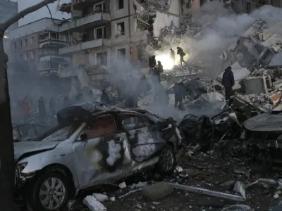 Emergency workers clear the rubble after a Russian rocket hit a multistory building leaving many people under debris in Dnipro, Ukraine, Saturday, Jan. 14, 2023. (AP Photo/Roman Chop)