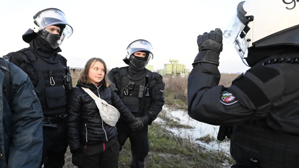 Police officers take Swedish climate activist Greta Thunberg away from the edge of the Garzweiler II opencast lignite mine during a protest action by climate activists after the clearance of Luetzerath, Germany, Tuesday, Jan. 17, 2023. After the eviction of Luetzerath ended on Sunday, coal opponents continued their protests on Tuesday at several locations in North Rhine-Westphalia. (Roberto Pfeil/dpa via AP)