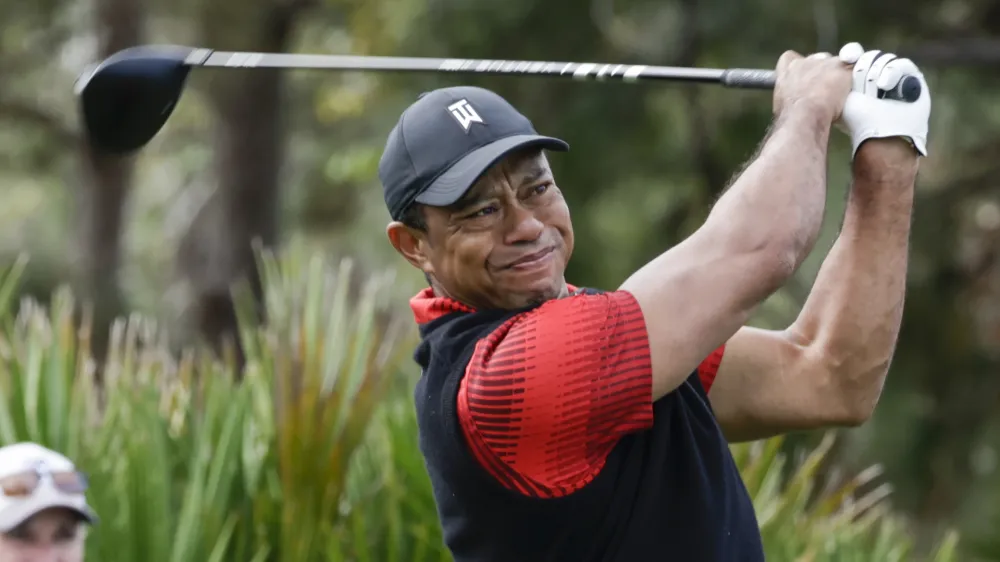 FILE - Tiger Woods tees off of the 3rd hole during the final round of the PNC Championship golf tournament on Dec. 18, 2022, in Orlando, Fla. Woods is returning to competition for the first time without the use of a cart since July, announcing Friday, Feb. 10, 2023, that he will play next week at Riviera in the Genesis Invitational. (AP Photo/Kevin Kolczynski, File)