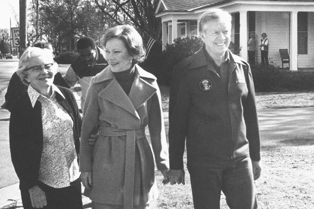 FILE - Former President Jimmy Carter, right, wife Rosalynn, center, and mother-in-law Allie Smith walk through Plains, Ga., Jan. 23, 1981, back home from their office. Well-wishes and fond remembrances for the former president continued to roll in Sunday, Feb. 19, 2023, a day after he entered hospice care at his home in Georgia. (AP Photo/Wayne Perkins, File)