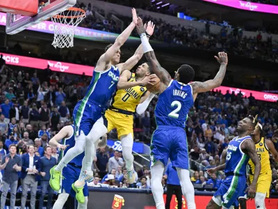 Feb 28, 2023; Dallas, Texas, USA; Indiana Pacers guard Tyrese Haliburton (0) is fouled by Dallas Mavericks center Dwight Powell (7) as guard Kyrie Irving (2) defends the basket during the second half at the American Airlines Center. Mandatory Credit: Jerome Miron-USA TODAY Sports