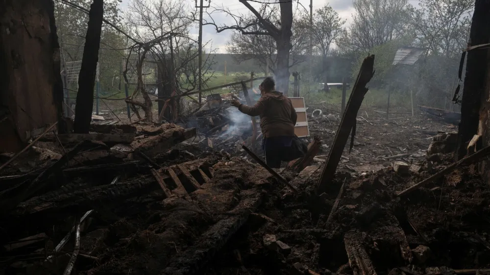 Tatiana Makohon, 56-year-old, carries items from a house of her friend destroyed by a Russian drone strike in the village of Malotaranivka, amid Russia's attack on Ukraine, in Donetsk region, Ukraine April 29, 2023. REUTERS/Sofiia Gatilova