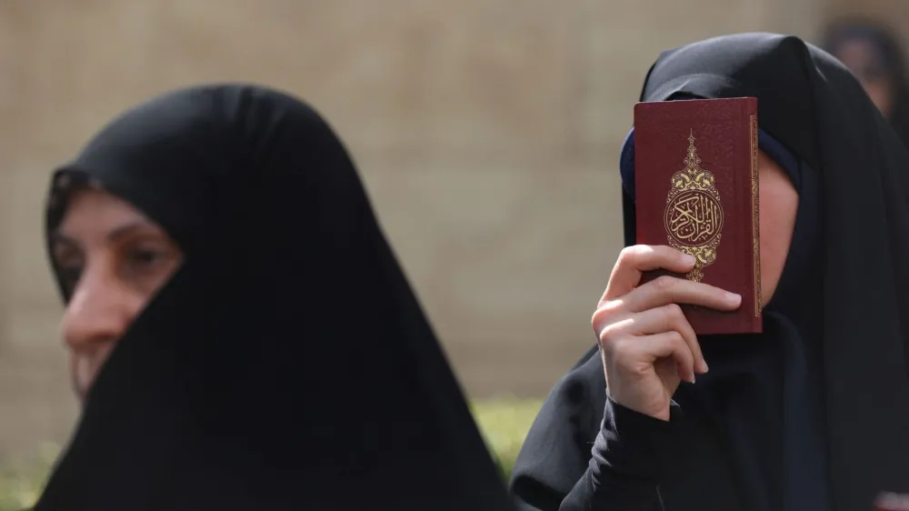 An Iranian protester holds the Koran in her hand, during a protest against a man who burned a copy of the book outside a mosque in the Swedish capital Stockholm, in front of the Swedish Embassy in Tehran, Iran July 3, 2023. Majid Asgaripour/WANA (West Asia News Agency) via REUTERS ATTENTION EDITORS - THIS PICTURE WAS PROVIDED BY A THIRD PARTY.