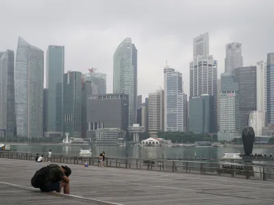 FILE - A man takes a nap as the central business district is shrouded by haze in Singapore, on Sept. 23, 2019. Singapore executed a man Wednesday, July 26, 2023, for drug trafficking and is set to hang a woman Friday — the first in 19 years — prompting renewed calls for a halt to capital punishment. (AP Photo/Vincent Thian, File)