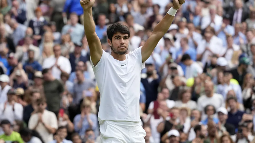 Spain's Carlos Alcaraz celebrates after beating Denmark's Holger Rune to win their men's singles match on day ten of the Wimbledon tennis championships in London, Wednesday, July 12, 2023. (AP Photo/Kirsty Wigglesworth)