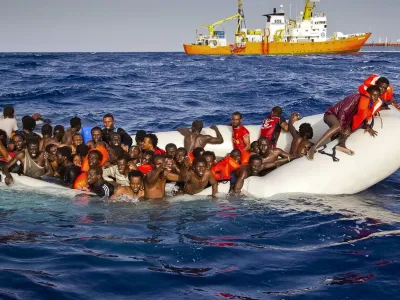 ﻿In this photo taken on Sunday, April 17, 2016 migrants ask for help from a dinghy boat as they are approached by the SOS Mediterranee's ship Aquarius, background, off the coast of the Italian island of Lampedusa. The European Union's border agency says the number of migrants crossing the Mediterranean Sea to Italy more than doubled last month. Frontex said in a statement on Monday that almost 9,600 migrants attempted the crossing, one of the most perilous sea voyages for people seeking sanctuary or jobs in Europe. (Patrick Bar/SOS Mediterranee via AP)