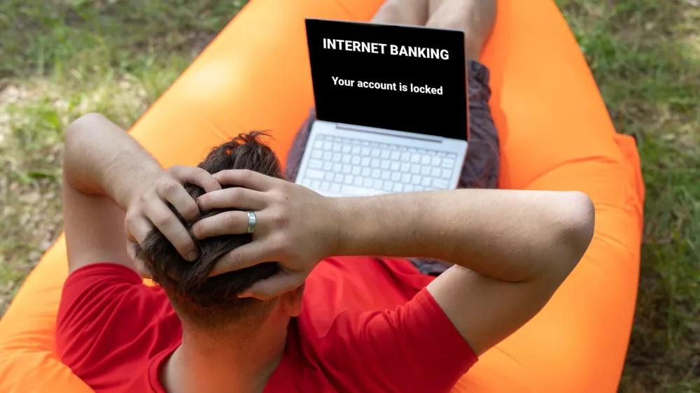 W8T0D2 Online scam concept, internet banking error. Your accaunt is locked on laptop screen. <br>alarmed man clutching his head<br><br>spletne prevare