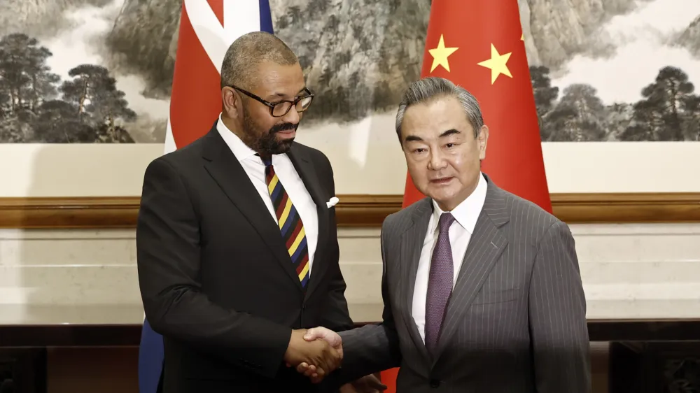 British Foreign Secretary James Cleverly, left, and Chinese Foreign Minister Wang Yi shake hands before a meeting at the Diaoyutai State Guesthouse in Beijing, Wednesday, Aug. 30, 2023. (Florence Lo/Pool Photo via AP)