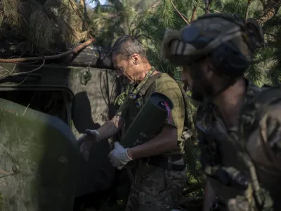 Ukrainian soldiers load a howitzer with a shell on the front line in the outskirts of Lyman, Ukraine, Tuesday, Aug. 15, 2023. Moscow's army is staging a ferocious push in northeast Ukraine designed to distract Ukrainian forces from their counteroffensive and minimize the number of troops Kyiv is able to send to more important battles in the south. (AP Photo/Bram Janssen)