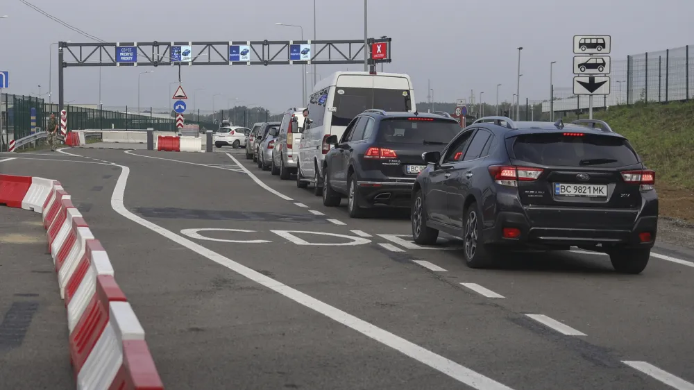 FILE - Cars queue towards Poland at the Krakovets - Korcheva border crossing point in Krakovets, Ukraine, Tuesday, Aug. 16, 2022. Poland has begun enforcing an entry ban on all Russian-registered passenger cars seeking to enter the country. The move comes just days after the nearby Baltic states of Lithuania, Latvia and Estonia banned vehicles with Russian license plates from entering their territory. (AP Photo/Roman Baluk, File)