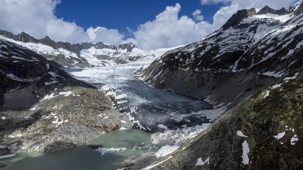 FILE - A lake of meltwater has formed on the tongue of the Rhone Glacier near Goms, Switzerland, on June 13, 2023. A Swiss Academy of Sciences panel is reporting a dramatic acceleration of glacier melt in the Alpine country, which has lost 10% of its ice volume in just two years after high summer heat and low snow volumes in winter. (AP Photo/Matthias Schrader, File)