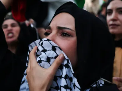 A woman looks on during a protest to express support for Palestinians, in Rome, Italy, October 13, 2023. REUTERS/Yara Nardi