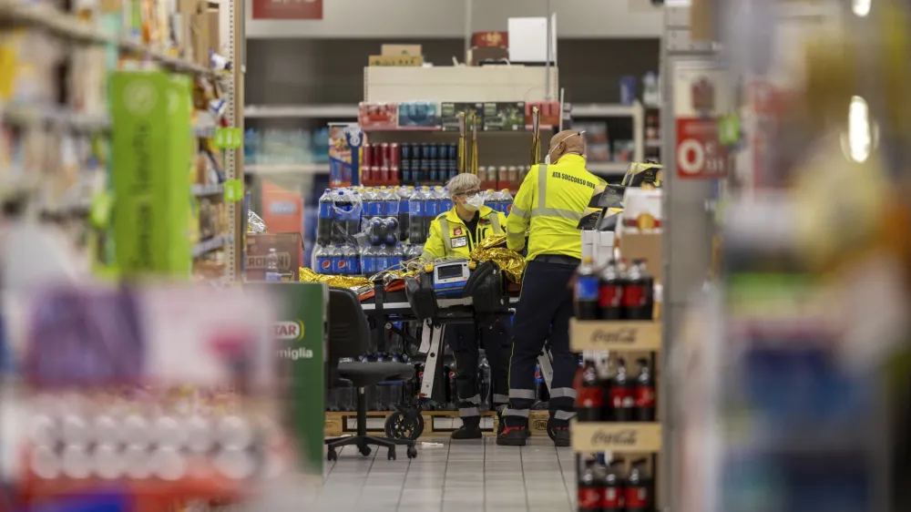 Emergency personnel attend to a scene of an attack in Milan, Italy, Thursday Oct. 27, 2022. A man armed with a knife stabbed five people inside a shopping center south of Milan on Thursday. (LaPresse via AP)