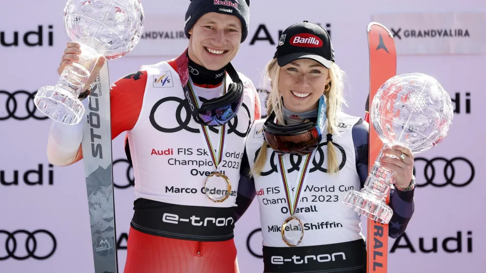 Alpine Skiing - FIS Alpine Ski World Cup - Men's Slalom - Soldeu, Andorra - March 19, 2023 Switzerland's Marco Odermatt and Mikaela Shiffrin of the U.S. celebrate on the podium with their globe trophies after winning the men's and women's overall standing REUTERS/Albert Gea