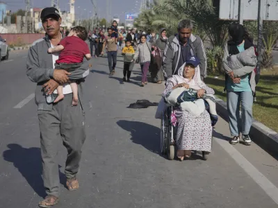 Palestinians flee to the southern Gaza Strip on Salah al-Din Street in Bureij, Gaza Strip, Tuesday, Nov. 7, 2023. (AP Photo/Hatem Moussa)