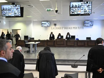 Facing the camera, President of the court Judge Brigida Cavasino, center, flanked by judges Claudia Caputo, left, and Germana Radice reads the sentence of a maxi-trial of hundreds of people accused of membership in Italy's 'ndrangheta organized crime syndicate, one of the world's most powerful, extensive and wealthy drug-trafficking groups, in Lamezia Terme, southern Italy, Monday, Nov. 20, 2023. The trial started almost three years ago in the southern Calabria region, where the mob organization was originally based. (AP Photo/Valeria Ferraro)