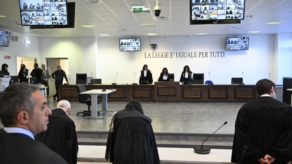 Facing the camera, President of the court Judge Brigida Cavasino, center, flanked by judges Claudia Caputo, left, and Germana Radice reads the sentence of a maxi-trial of hundreds of people accused of membership in Italy's 'ndrangheta organized crime syndicate, one of the world's most powerful, extensive and wealthy drug-trafficking groups, in Lamezia Terme, southern Italy, Monday, Nov. 20, 2023. The trial started almost three years ago in the southern Calabria region, where the mob organization was originally based. (AP Photo/Valeria Ferraro)