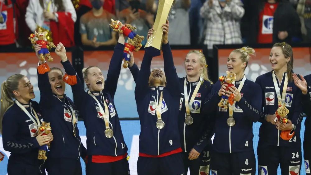 ﻿Norway's Mora Mork lifts the trophy as team players celebrate after beating France during the final of the Women's Handball World Championship in Granollers, Spain, Sunday, Dec. 19, 2021. (AP Photo/Joan Monfort)