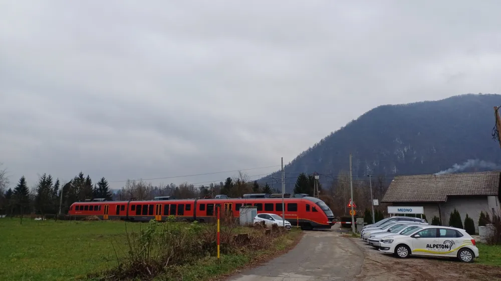 Neuradno parkirišče ob medenskem železniškem postajališču, kjer je na območju z nasutim peskom prostora za pet, šest parkiranih vozil.