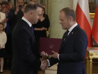 Poland's new Prime Minister Donald Tusk, right, shakes hands with Poland's President Andrzej Duda during the swearing-in ceremony at the presidential palace in Warsaw, Poland, Wednesday, Dec. 13, 2023. Donald Tusk was sworn in by the president in a ceremony where each of his ministers was also taking the oath of office. (AP Photo/Czarek Sokolowski)