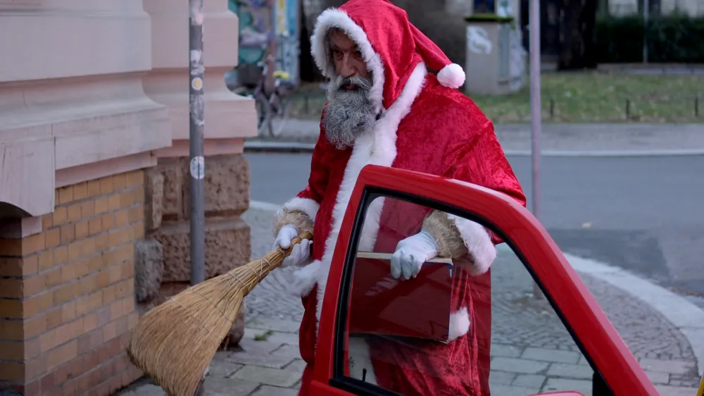 24 December 2023, Saxony, Leipzig: Andre Adelinia gets out of his car in the role of Santa Claus to give presents to children. He has been working as Santa Claus for children in his circle of friends for 15 years. Photo: Sebastian Willnow/dpa