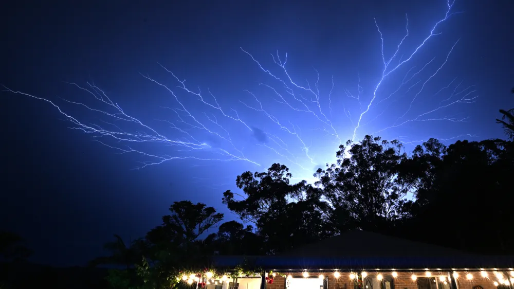 An electrical storm is seen at Reedy Creek on the Gold Coast Monday, December 25, 2023. A woman has died after being struck by a tree after winds of 100 kph lashed the Gold Coast, bringing down trees, powerlines. (AAP Image/Dave Hunt) NO ARCHIVING