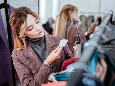 Check price. Elegant fashionable businesswoman shopping on weekend checking the price of dress / Foto: Yacobchuk