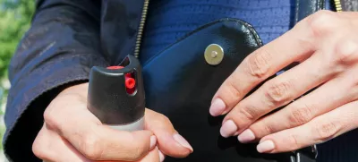 A young woman pulls a can of tear gas or bottle of pepper spray out of her purse. Means of self-defense, protection from robbery and rape.. Selective focus, close-up. / Foto: Evgen_prozhyrko