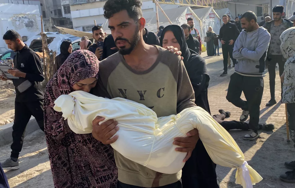 15 November 2024, Palestinian Territories, Gaza: A man holds the body of a Palestinian child who was killed in Israeli attacks on Sheikh Ridwan neighborhood, in the Al-Ahli Baptist hospital for the funeral procedures in Gaza City. Photo: Hadi Daoud Apaimages/APA Images via ZUMA Press Wire/dpa