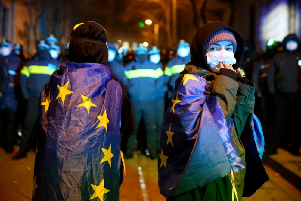 People wrapped in the European Union flags attend a rally held by supporters of Georgia's opposition parties to protest against the government's decision to suspend talks on joining the European Union in Tbilisi, Georgia December 4, 2024. REUTERS/Irakli Gedenidze