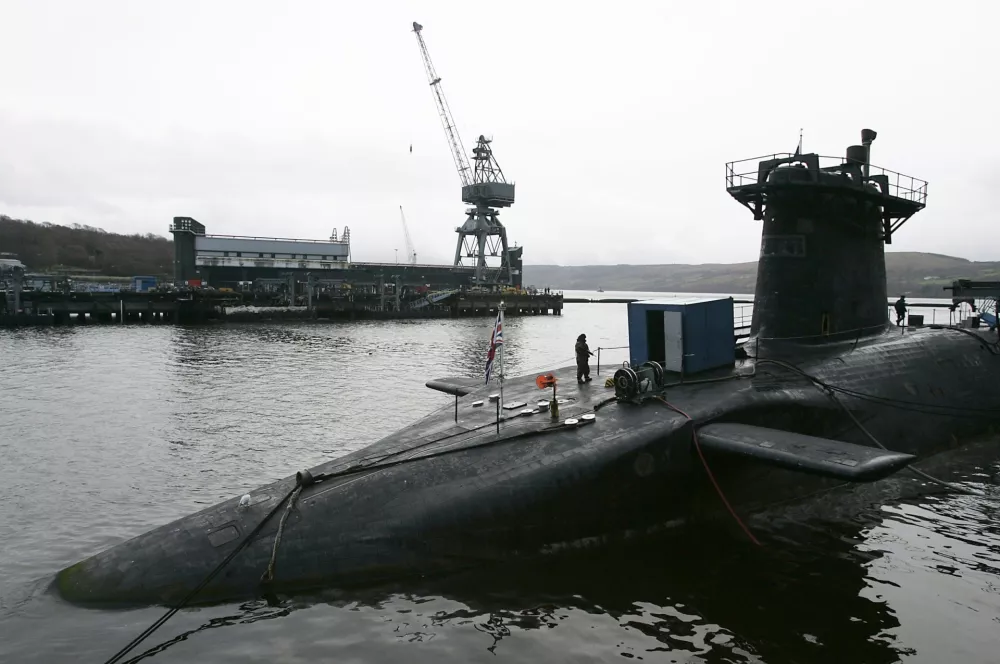 A Royal Marine soldier is seen standing guard on submarine HMS Vanguard moored at the Faslane naval base near Glasgow, Scotland in this December 4, 2006 file photograph. Two nuclear-armed submarines, one British and one French, collided underwater while on separate patrols in the Atlantic Ocean, the head of the Royal Navy said on February 16, 2009. REUTERS/David Moir/Files (BRITAIN)