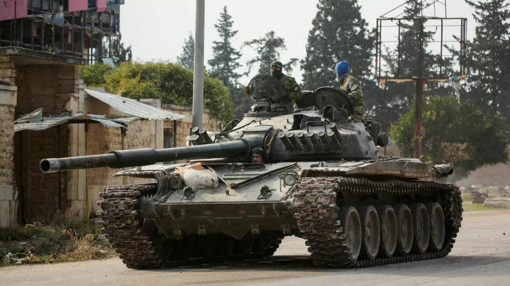 FILE PHOTO: Rebels led by the Islamist militant group Hayat Tahrir al-Sham drive a military vehicle in al-Rashideen, Aleppo province, Syria November 29, 2024. REUTERS/Mahmoud Hasano/File Photo