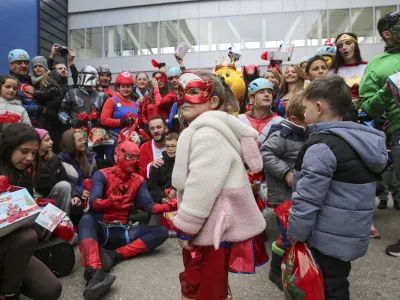 Children dressed as superheroes greet Kosovo alpinists disguised as super-heroes of modern times delivering New Year's gifts to children patients in Pristina hospital on Friday, Dec. 13, 20124. (AP Photo/Visar Kryeziu)