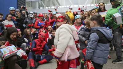 Children dressed as superheroes greet Kosovo alpinists disguised as super-heroes of modern times delivering New Year's gifts to children patients in Pristina hospital on Friday, Dec. 13, 20124. (AP Photo/Visar Kryeziu)