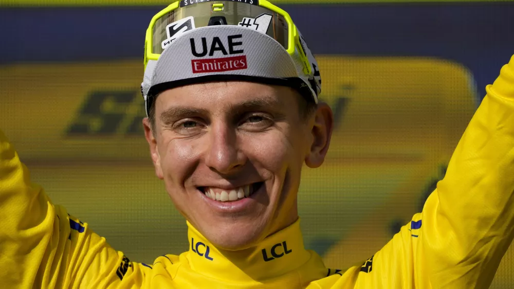 Slovenia's Tadej Pogacar, wearing the overall leader's yellow jersey, celebrates on the podium after the twentieth stage of the Tour de France cycling race over 132.8 kilometers (82.5 miles) with start in Nice and finish in La Couillole pass, France, Saturday, July 20, 2024. (AP Photo/Jerome Delay)