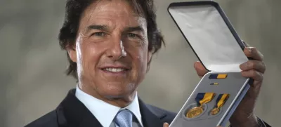 Tom Cruise receives a Navy Distinguished Public Service Award from The United States Secretary of the Navy Carlos Del Toro presents at the Longcross South Studios, in Runnymede, Surrey, England, Tuesday, Dec. 17, 2024. (AP Photo/Kin Cheung)