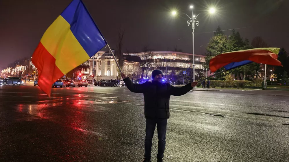 A man waves Romanian flags at Victory Square, after the annulment of the presidential election result, in Bucharest, Romania, December 6, 2024. REUTERS/Louisa Gouliamaki