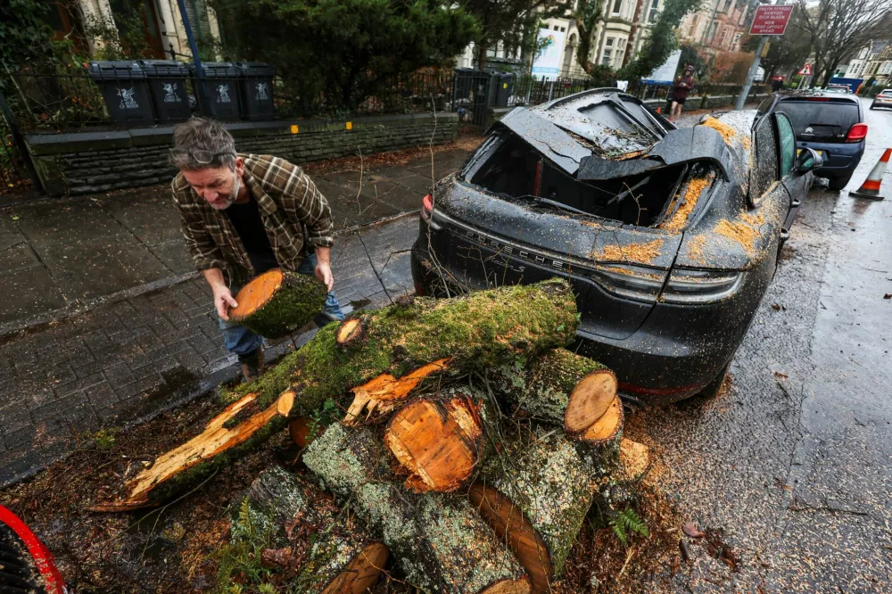 A person begins to remove fallen tree branches, after Storm Darragh hit the country in Penarth, Wales, Britain, December 7, 2024. REUTERS/Temilade Adelaja