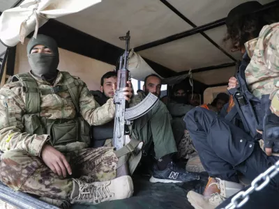 Rebel fighters sit together in Homs countryside, after Syrian rebels pressed their lightning advance on Saturday, saying they had seized most of the south, as government forces dug in to defend the key central city of Homs to try to save President Bashar al-Assad's 24-year rule, in Syria December 7, 2024. REUTERS/Mahmoud Hasano