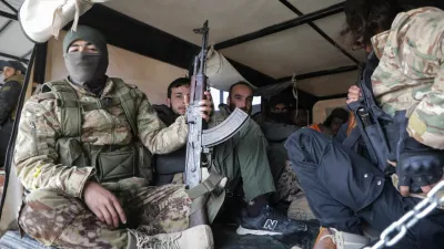 Rebel fighters sit together in Homs countryside, after Syrian rebels pressed their lightning advance on Saturday, saying they had seized most of the south, as government forces dug in to defend the key central city of Homs to try to save President Bashar al-Assad's 24-year rule, in Syria December 7, 2024. REUTERS/Mahmoud Hasano