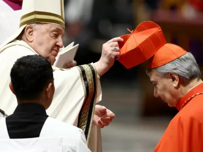 Pope Francis places the traditional red biretta, a four-cornered hat, on the head of new Cardinal Domenico Battaglia during a consistory ceremony to elevate Roman Catholic prelates to the rank of cardinal, in Saint Peter's Basilica at the Vatican, December 7, 2024. REUTERS/Guglielmo Mangiapane