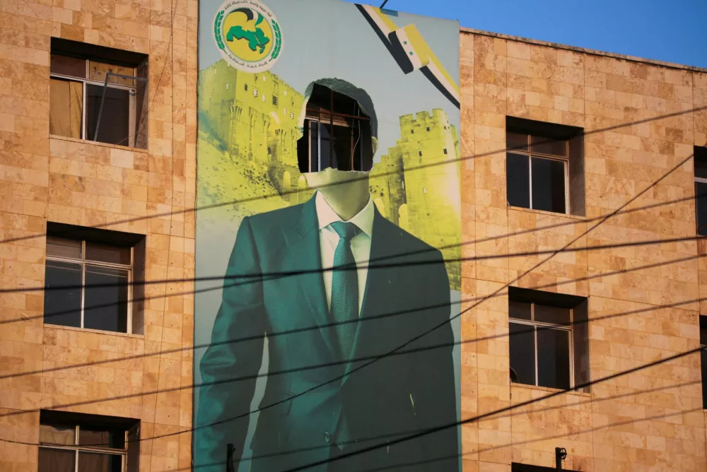 FILE PHOTO: A view shows a damaged poster of Syria's President Bashar al-Assad in Aleppo, after the Syrian army said that dozens of its soldiers had been killed in a major attack by rebels who swept into the city, in Syria November 30, 2024. REUTERS/Mahmoud Hassano   TPX IMAGES OF THE DAY/File Photo