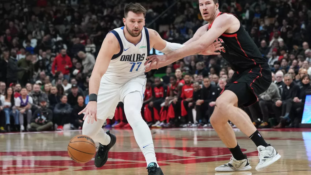 Dec 7, 2024; Toronto, Ontario, CAN; Dallas Mavericks guard Luka Doncic (77) controls the ball against Toronto Raptors center Jakob Poeltl (19) during the first quarter at Scotiabank Arena. Mandatory Credit: Nick Turchiaro-Imagn Images